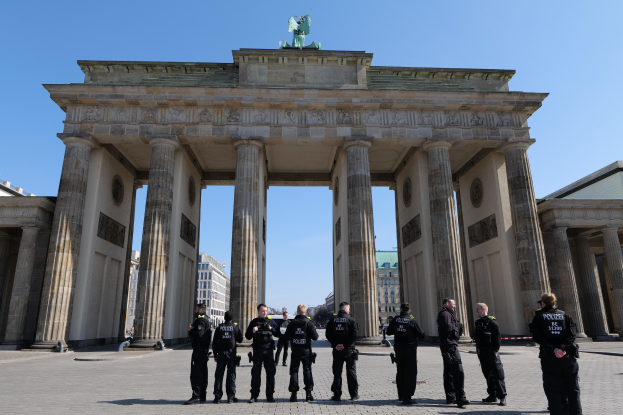 Gruppe von Polizeibeamten vor dem Brandenburger Tor in Berlin, Deutschland, mit Bogen, Säulen und Statue.