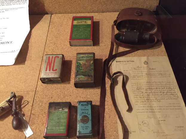 Ein Korkbrett mit verschiedenen daran gehefteten oder befestigten Gegenständen, darunter Kartons, Papiere und eine Tasche.