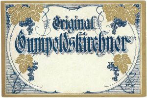 Ein altes deutsches Wein-Etikett mit einer Illustration von Trauben und Blättern und einem Text, der den Wein-Typ angibt.