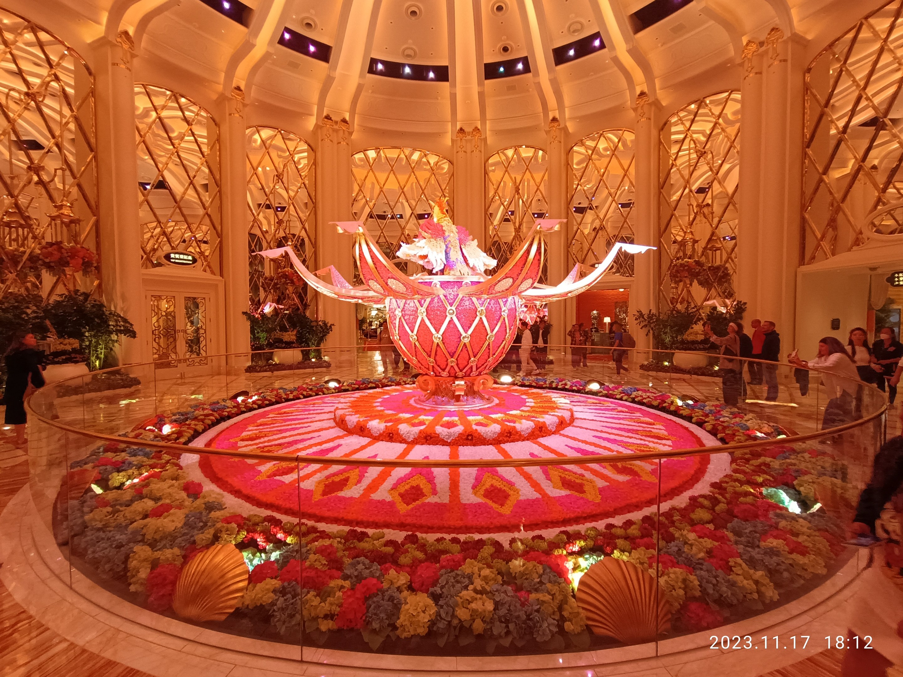 Das Bellagio Hotel und Casino in Las Vegas, Nevada, mit Menschen und dekorativen Blumenarrangements auf dem Boden, Säulen und Lichtern im Hintergrund.