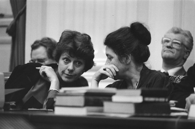 Zwei Frauen an einem Tisch in einer schwarz-weißen Gerichtsszene, wobei eine wie eine Richterin und die andere wahrscheinlich eine Prozessbeteiligte ist.