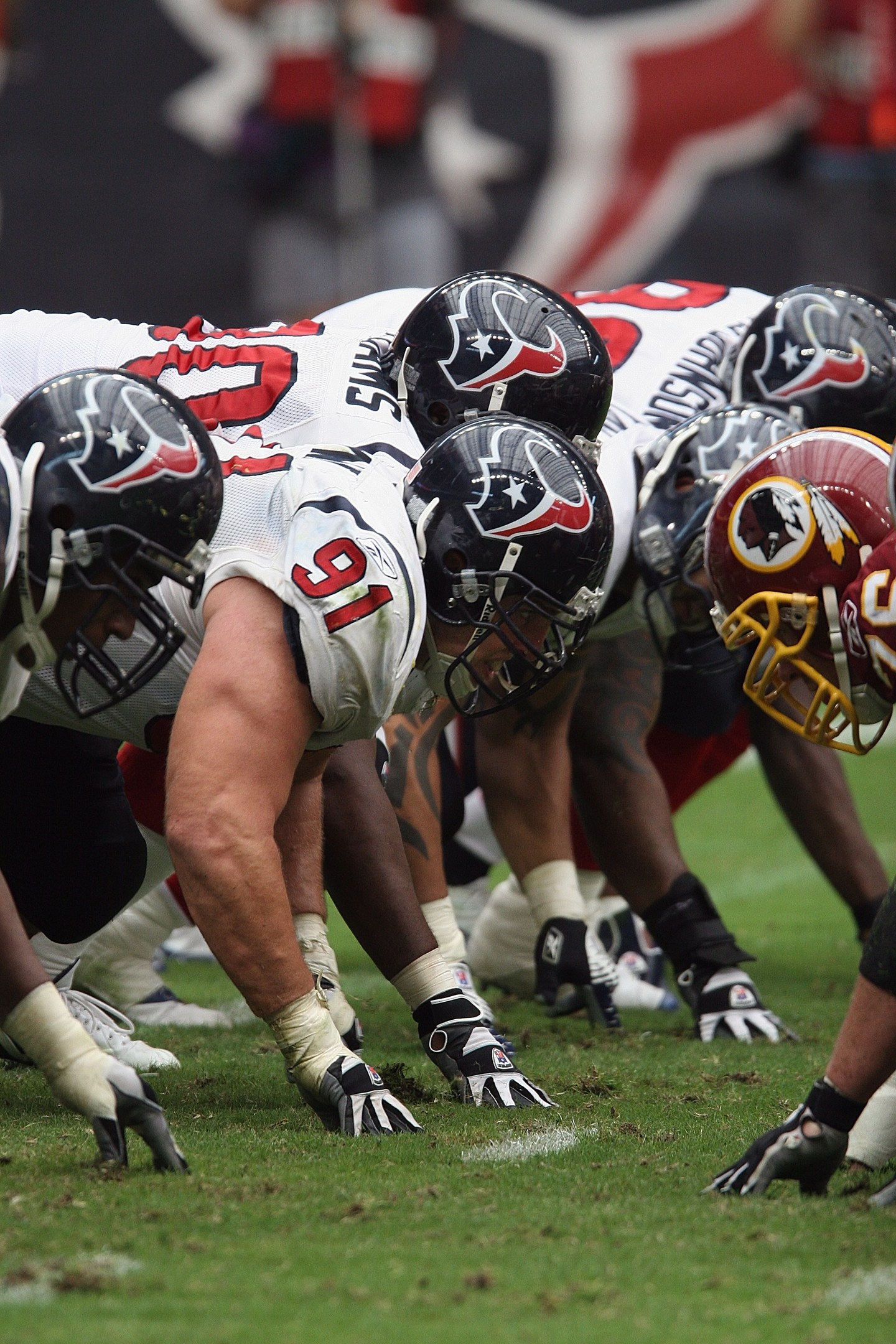 Gruppe von Fußballspielern in Helmen und Handschuhen auf dem Feld mit einem unscharfen Hintergrund.