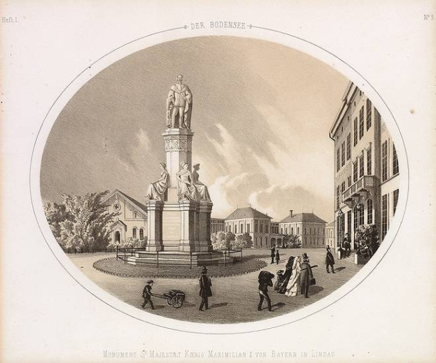 Schwarz-weiß-Zeichnung einer Statue des Heiligen Majestrat König Maximilian I. von Bayern in einem Stadtplatz, umgeben von Gebäuden, Bäumen und Menschen, mit Text unten und Himmel im Hintergrund.