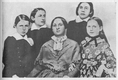 Schwarzes und weißes Foto einer vielfältigen Gruppe von Frauen mit einer sitzenden Frau in der Mitte, verbunden mit dem Text "Die Frauenwahlrechtsbewegung" unten.