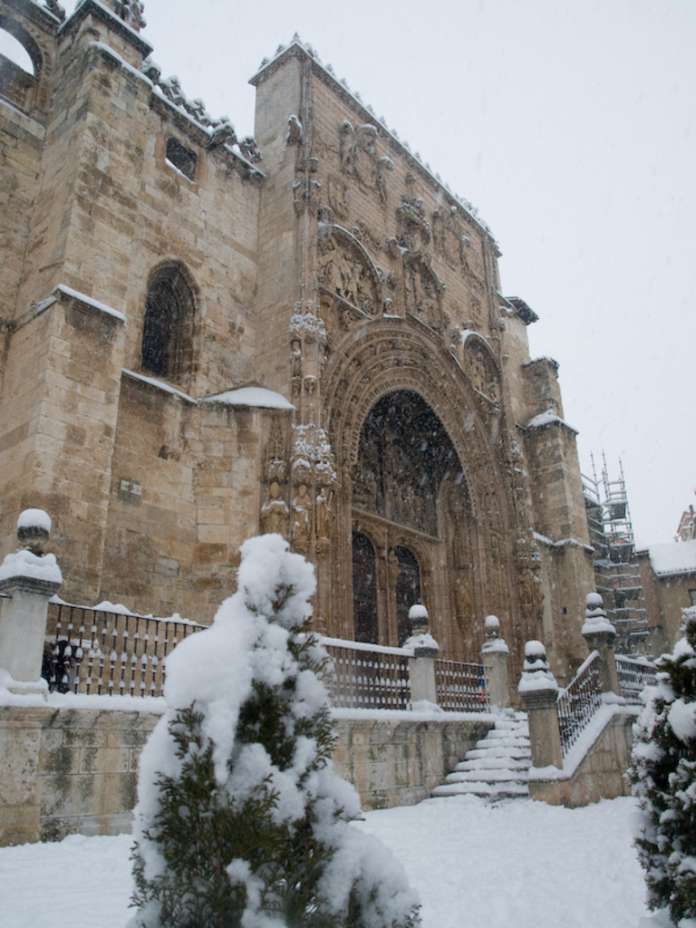 Eine architektonische Struktur mit einer beträchtlichen Menge an Schnee davor und mit Eis bedeckten Bäumen.