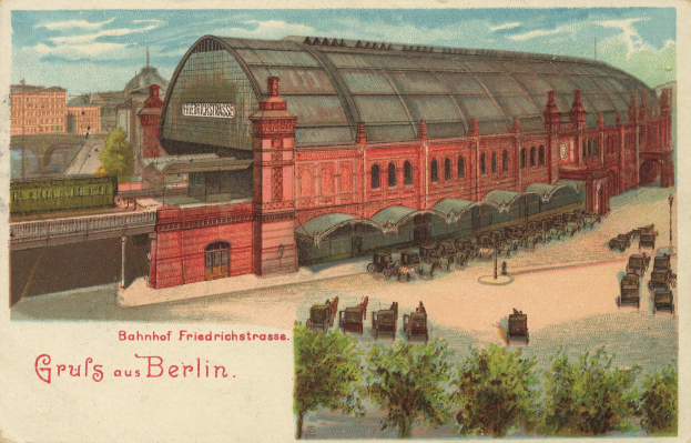 Alte Postkarte, die eine Bahnstation in Berlin, Deutschland zeigt, mit einem Gebäude, Bäumen, Karren, Menschen, einer Brücke und einem bewölkten Himmel, einschließlich Text unten.