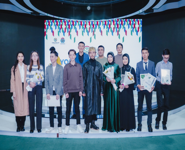 Gruppe von Menschen auf einer Bühne mit Blumensträußen und Urkunden vor dem Hintergrund "Jugend-Solar-Awards 2019"
