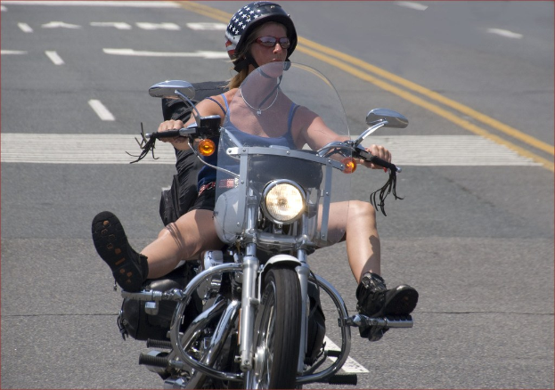 Frau in schwarzem Helm fährt Fahrrad auf Straße