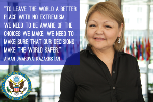 Eine Frau in einem schwarzen Kleid steht vor einem Fenster mit einem Zitat über die Gestaltung einer sichereren Welt, mit sichtbaren Flaggen im Hintergrund.