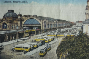 Schwarz-weiß-Postkarte des Dresdner Hauptbahnhofbahnhofs in Deutschland, die eine belebte Straßen Szene mit Fahrzeugen, Fußgängern, Bäumen, Gebäuden und einem bewölkten Himmel zeigt.