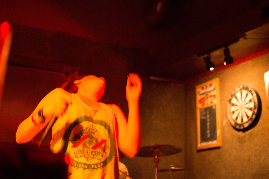 Eine Person in einem Oberteil tanzt mit Lichtern auf der rechten Seite.