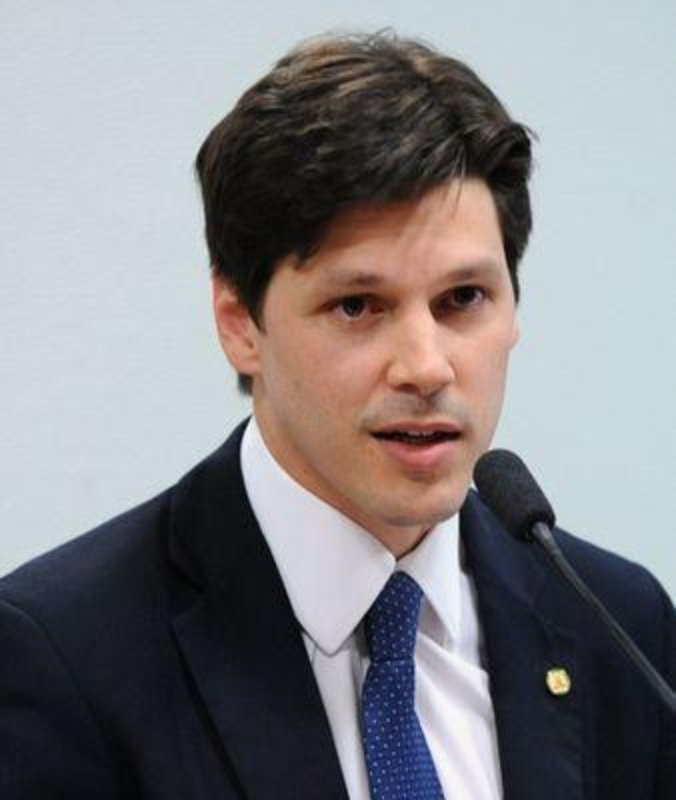 Ein Mann im Anzug spricht in ein Mikrofon an einem Pult, wahrscheinlich beim Vorlesen eines Regierungsgesetzes.