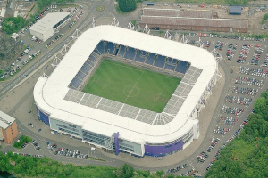 Luftaufnahme eines Fussballstadions in einer Stadt, umgeben von Gebäuden, Bäumen und Straßen mit Fahrzeugen, Heimat von Tottenham Hotspur Football Club.